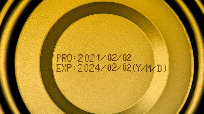 Top of a tin can with the production date and expiration date stamped on it