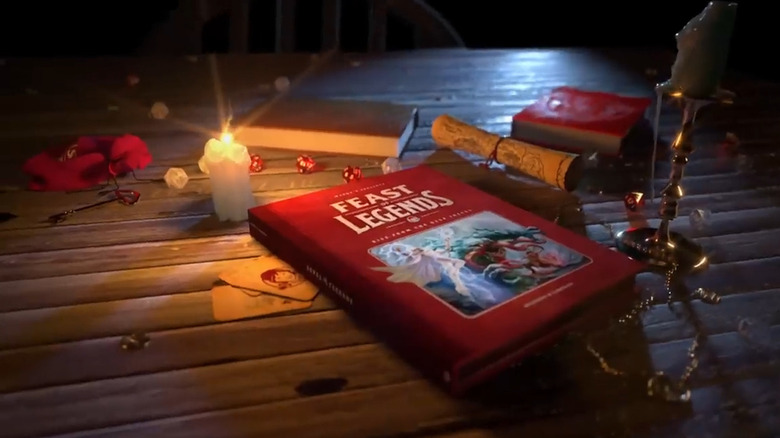 Feast of Legends tabletop game next to a candle and playing cards