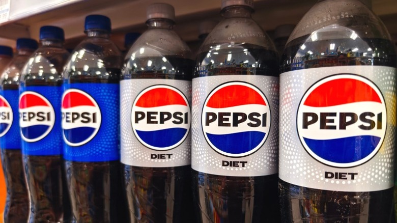 Bottles of Pepsi and Diet Pepsi sitting on a supermarket shelf.