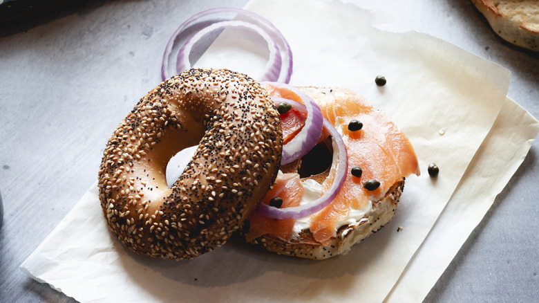 An everything bagel stacked with lox, red onion, and capers