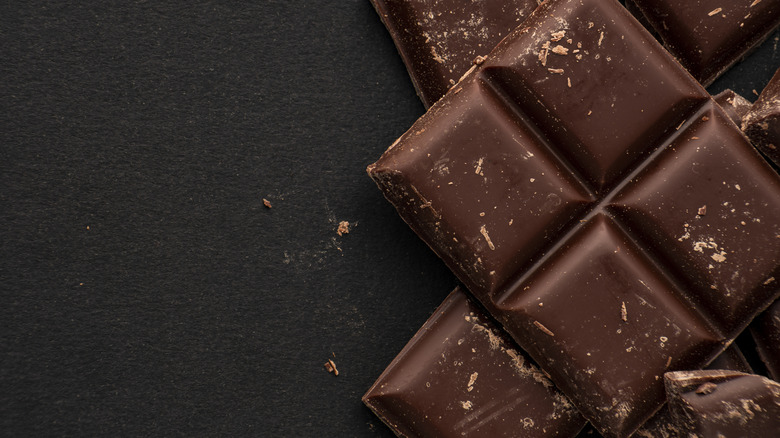 Square pieces of chocolate on a black surface