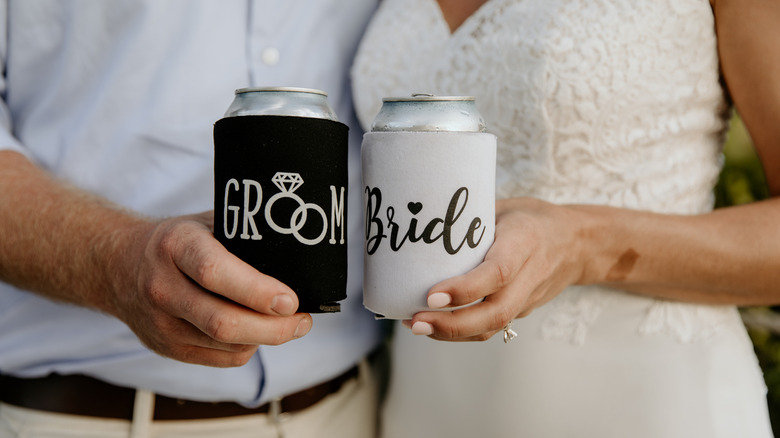 Bride and groom hold custom koozies