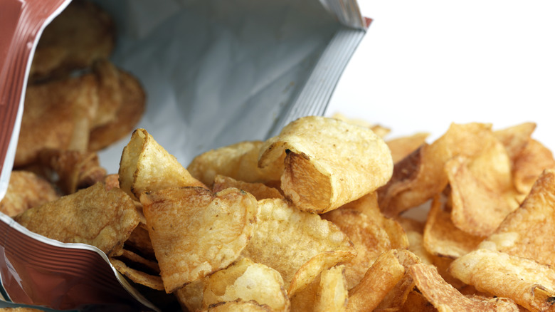 Potato chips spill out of a bag