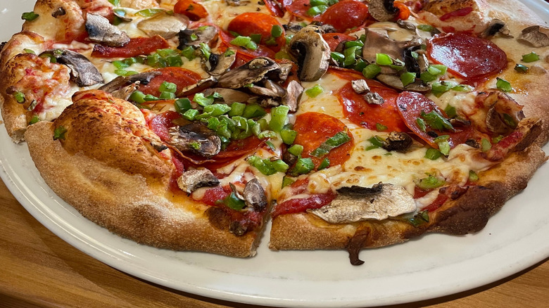 Greasy pizza topped with pepperoni, mushrooms, and peppers.