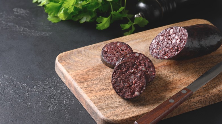 Slices of blood sausage sitting on a cutting board.