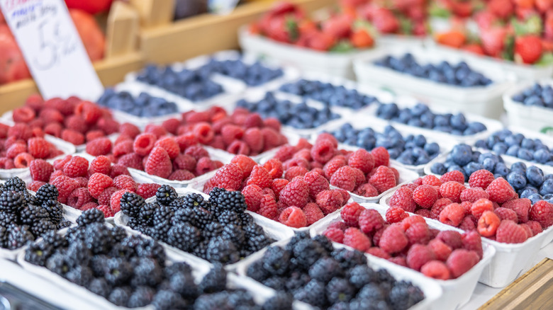 Containers of different fresh berries at a market