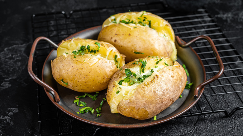 Baked potatoes topped with cheese and herbs