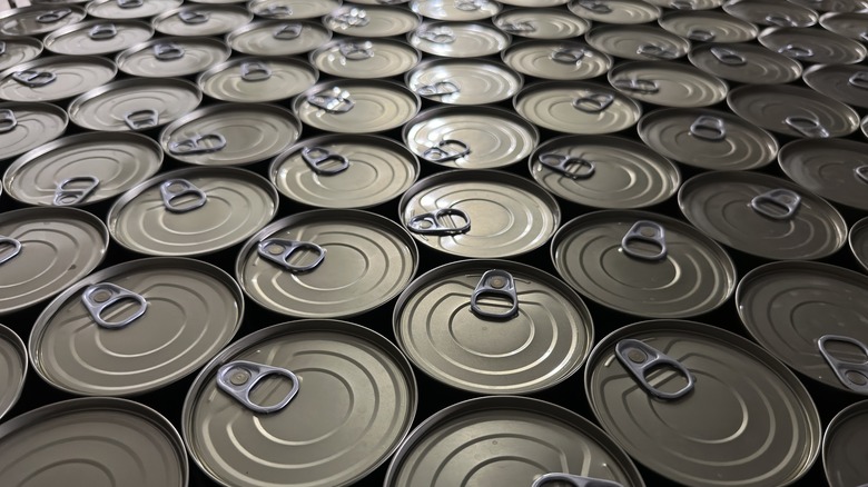 Many tops of unopened cans of tuna are shown together