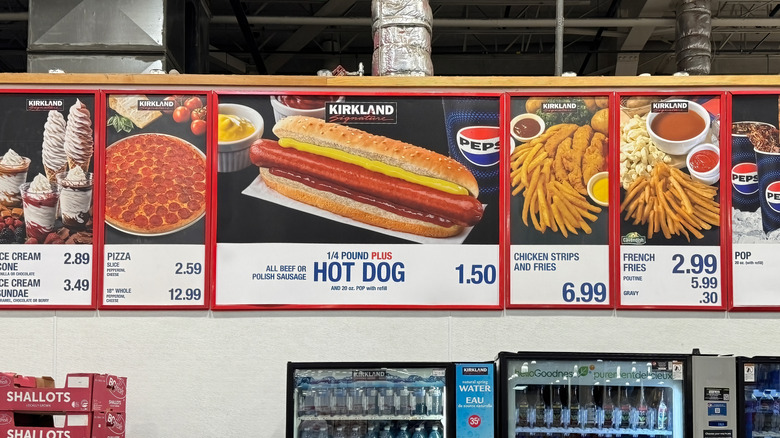 The Costco food court menu on display above empty shallot boxes and water machines.