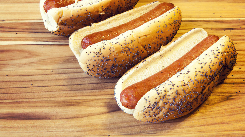 Three hot dogs in poppy seed buns