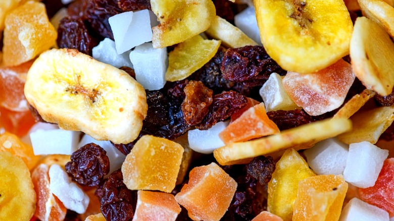 Close up shot of dried coconut, papaya, banana chips, and raisins