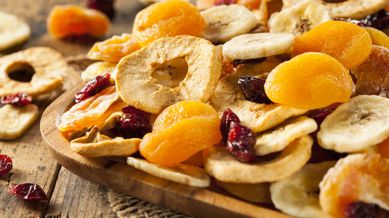 Wooden platter of dried apple rings, cranberries, and apricots