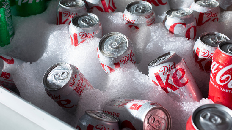 Cans of Diet Coke next to some standard Coca-Cola in ice.