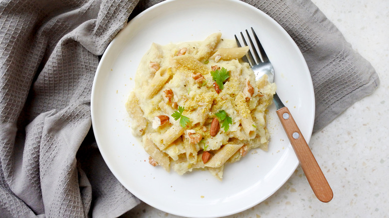 Creamy pasta topped with nutritional yeast flakes.