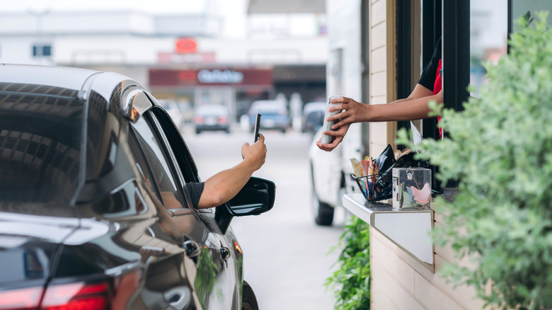 Someone paying at a drive-thru window