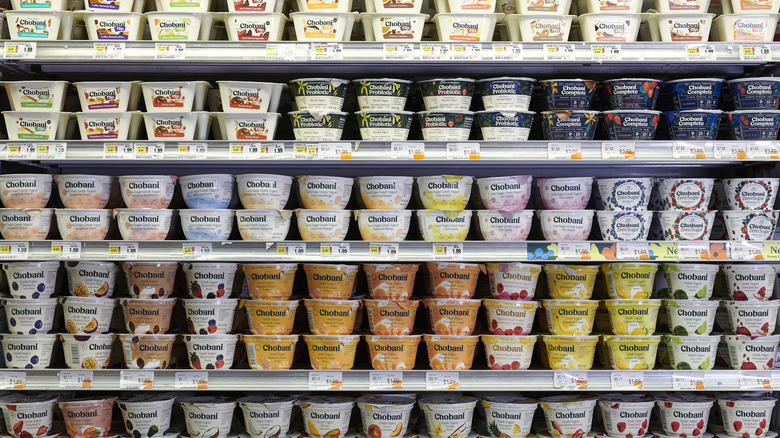 Grocery store shelf full of yogurts of different flavors