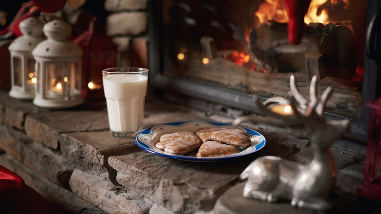 a plate of cookies and milk by a fireplace for Santa on Christmas