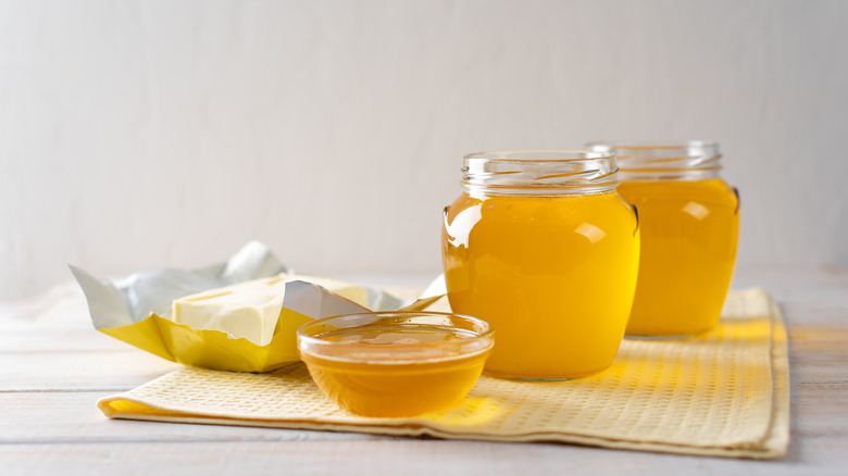 Hot melted ghee in several glass jars and dishes