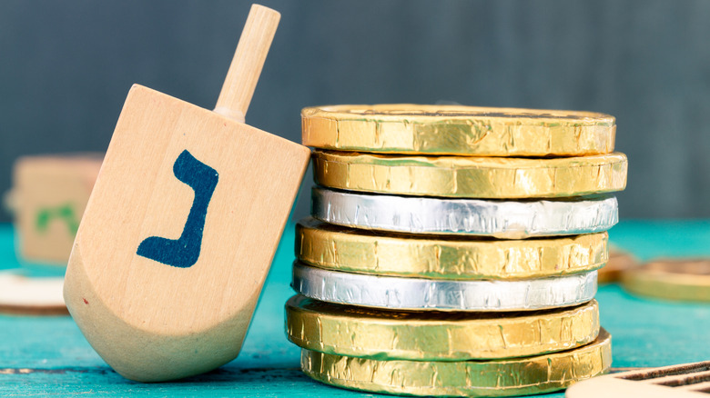 A stack of Hanukkah gelt coins with a dreidel