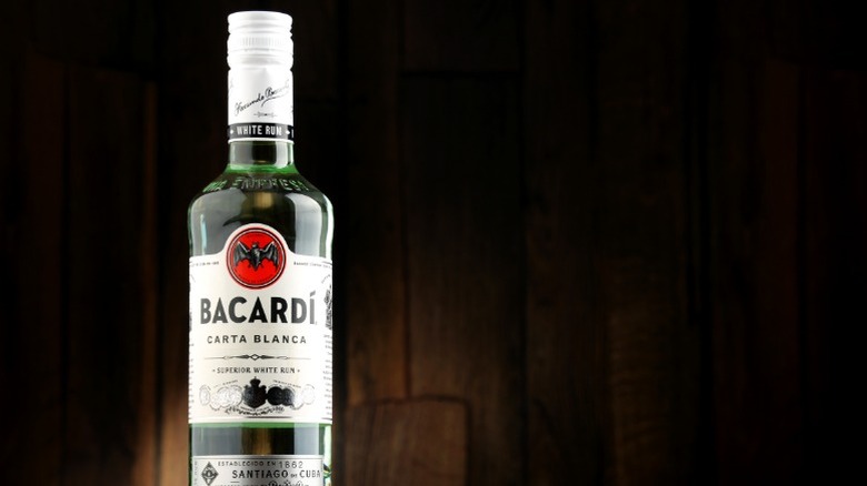 A bottle of Bacardí against a dark wood background