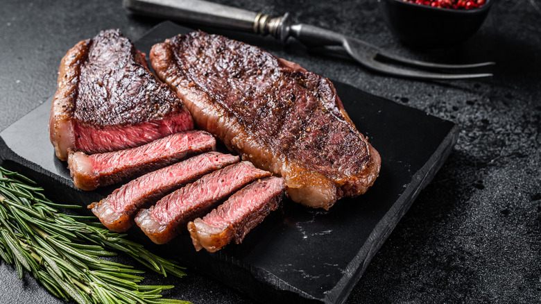 A sliced steak sitting on a board.