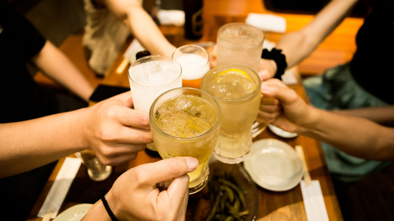 People clinking drinks at a Japanese pub.