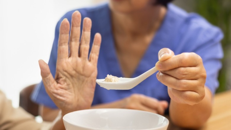 hand refusing a spoonful of food