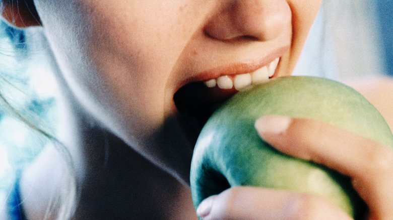 A person biting into an apple