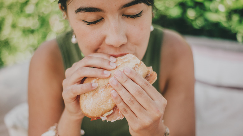 Person biting into a sandwich