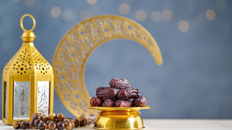 Dates resting on a stand in front of a decorative crescent moon.