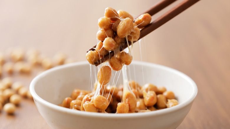 A person moving nattō using chopsticks.