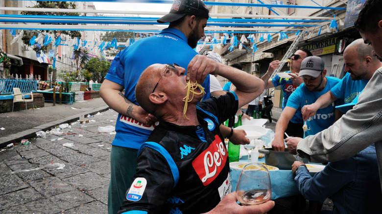 A person eating spaghetti with his fingers in Naples