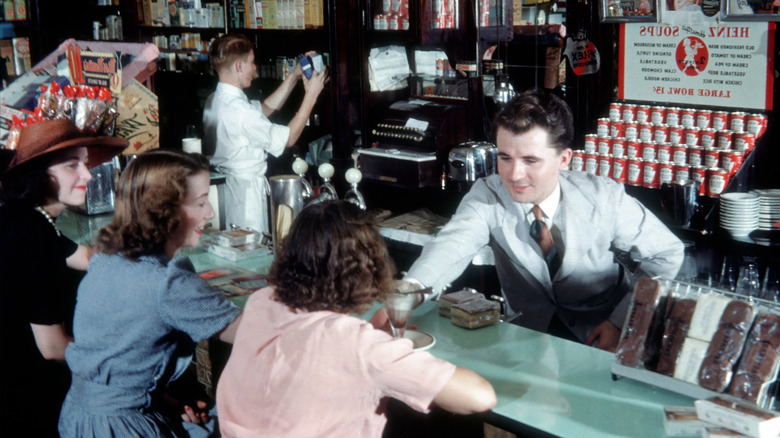 A pharmacist serves up an ice cream order to a customer at the counter