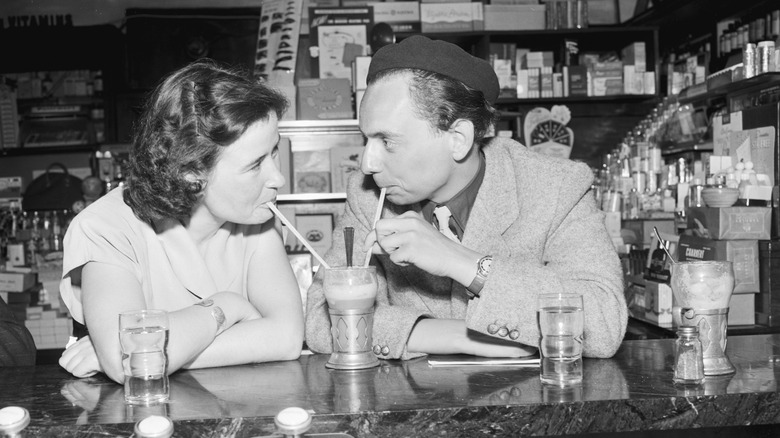 A couple splits a soda at a soda pharmacy