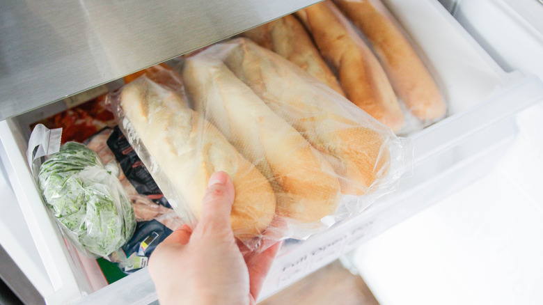 Putting fresh bread into a freezer