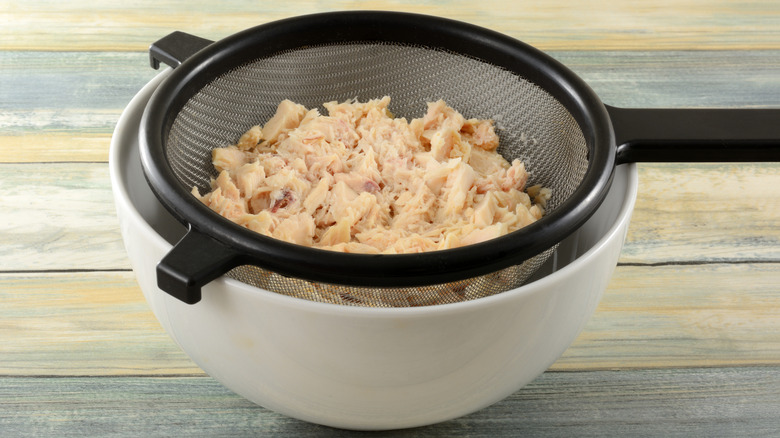 Draining tuna in a colander