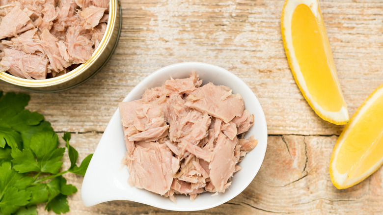 Canned tuna in bowl with lemon slices