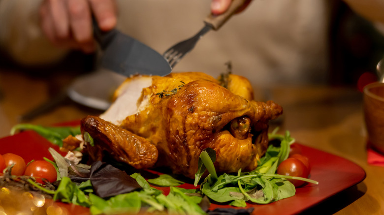 hands carving chicken