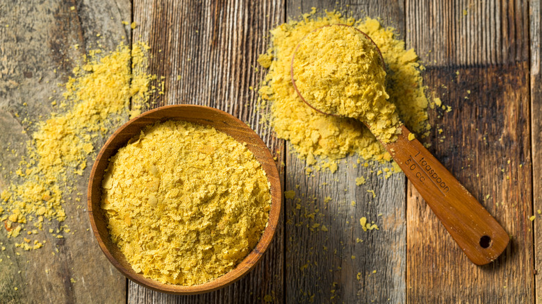 Nutritional yeast flakes in a wooden bowl and spoon