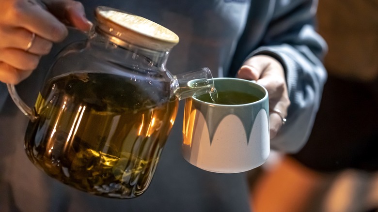 Woman pouring tea into mug