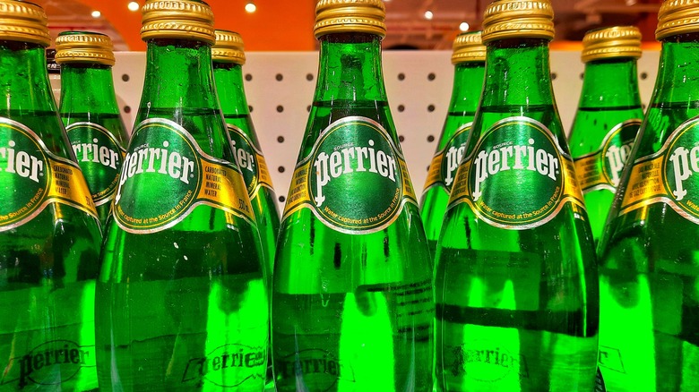 Two rows of green bottles of Perrier, a sparkling water brand.