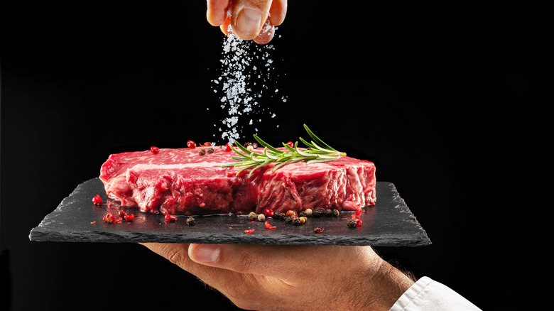 hand salting a raw steak