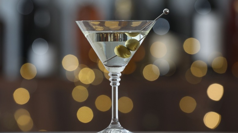 A martini in a glass with two skewered olives.