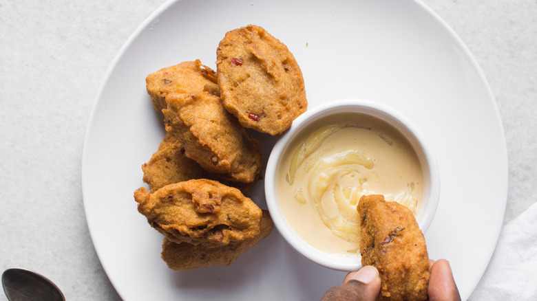 Akara from Nigeria on a plate with a dipping sauce in the middle