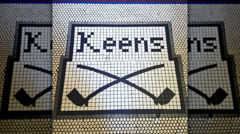 A mosaic on the floor of Keens Steakhouse that depicts two smoking pipes.