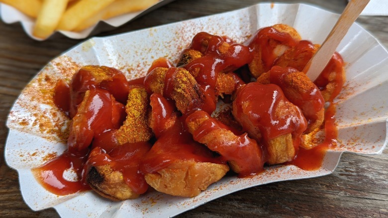 A serving of currywurst that's topped with ketchup.