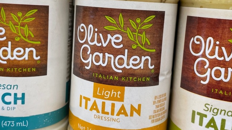 Labels for bottles of Olive Garden dressing varieties on grocery shelf