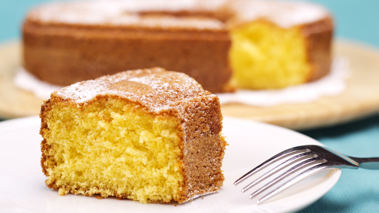 A slice of plain bundt cake with icing sugar on a plate