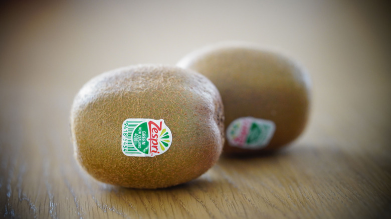 two kiwi with fruit stickers