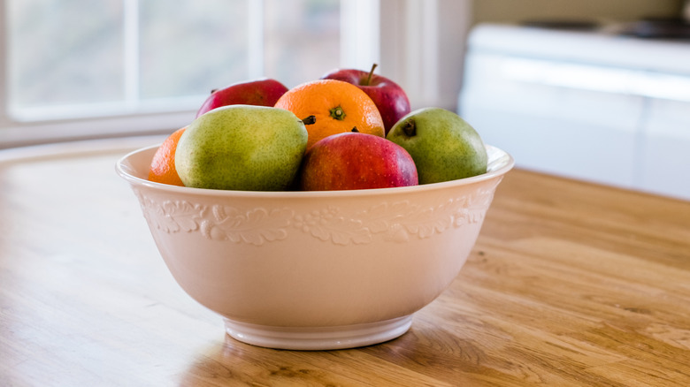 fruit in a white bowl on a kitchen table